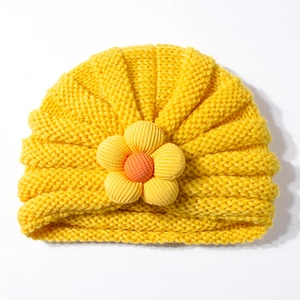 Dettaglio del cappello in maglia gialla per neonati con un fiore di girasole 3D