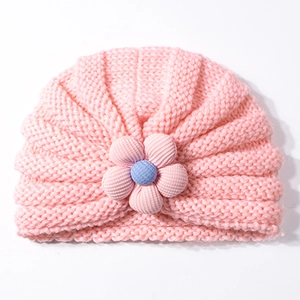 Dettaglio della trama in maglia rosa di un cappello neonato con fiore 3D per l'inverno
