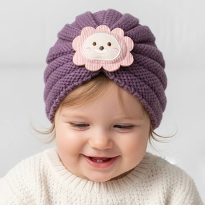 Texture de tricot détaillée du bonnet d'hiver violet pour bébé avec écusson lion