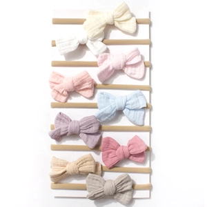 Set of 10 soft nylon bow headbands for babies in assorted Morandi colors on white display card