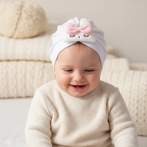 Close-up of baby in white thermal turban hat with cute pink bow rabbit applique detail