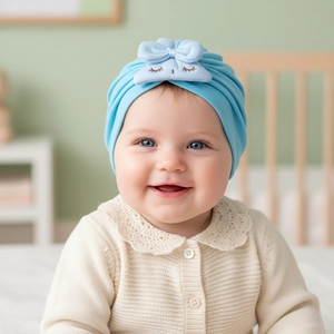 Close-up of sky blue baby turban hat with embroidered bow and soft knit texture