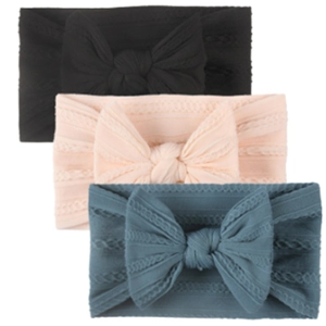 Détail de bandeaux bébé en nylon avec nœuds texturés en noir, rose et bleu ciel doux
