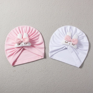 Detail of pink and white baby turban hats with cute rabbit embroidery and soft bows