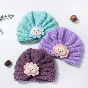 Texture détaillée de bonnets turban pour bébé en menthe et violet avec broderie lion