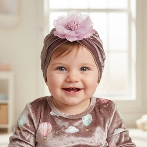 Détail du turban en velours pour bébé avec grande fleur en tulle 3D sur un modèle