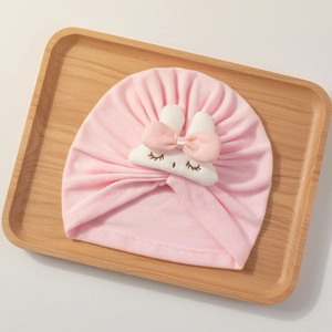Detail of baby turban hat with cute white plush rabbit and soft pink bow decoration