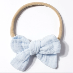 Detailed close-up of light blue cotton gauze bow with tan elastic nylon headband
