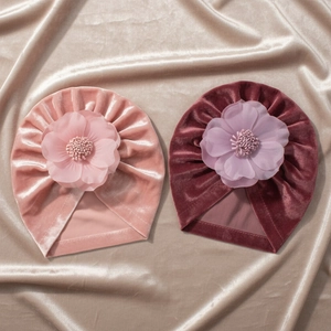 Vue détaillée de bonnets turban en velours pour bébé avec grandes fleurs en mousseline