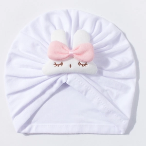 Detail of baby turban hat with pink bow and rabbit embroidery on white cotton fabric
