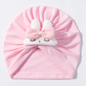 Detail of pink baby turban hat with white rabbit ears and soft knit texture finish