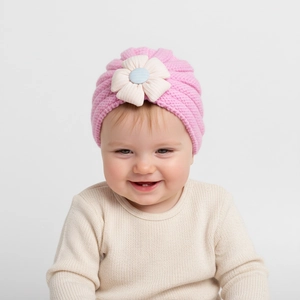 Close-up of baby rib-knit beanie with a large cream fabric flower and blue center