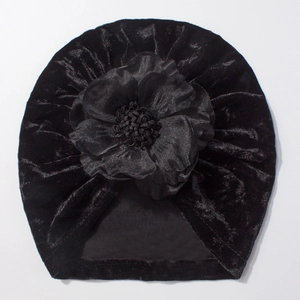 Détail du bonnet turban pour bébé en velours noir avec une grande fleur faite à la main