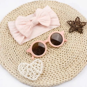 Ensemble bandeau bébé en maille rose et lunettes de soleil rondes pour l'été