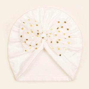 Détail d'un turban bébé blanc avec nœud à pois dorés et doublure chaude en polaire