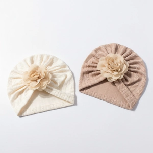 Détail de bonnets turbans tricotés pour bébé avec fleurs multicouches crème et marron clair