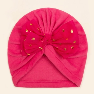 Détail du bonnet turban pour bébé rose avec un grand nœud à pois dorés brillants