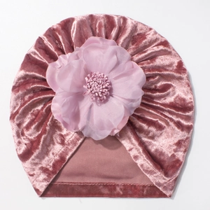 Détail du turban pour bébé en velours doré rose avec une grande fleur en tissu multicouche