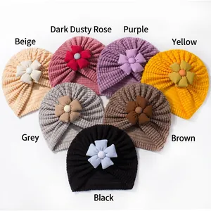 Detail showing seven waffle knit baby turbans with decorative fabric flowers in various colors