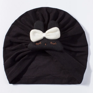 Detail of black knit baby turban with white bow and cute bunny embroidery