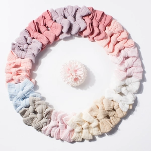 Set of colorful cotton baby bow headbands in various pastel shades arranged in a circle