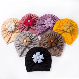 Soft knit baby turban hats with large fabric flowers in a variety of seven solid colors
