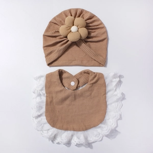 Dettaglio cappello neonato in cotone waffle kaki con fiore e bavaglino in pizzo