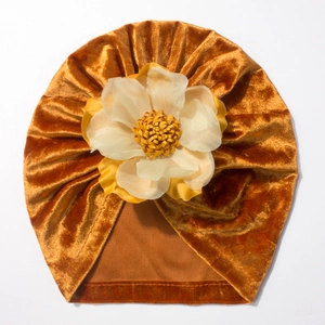 Détail du turban en velours orange pour bébé avec une grande fleur décorative artisanale