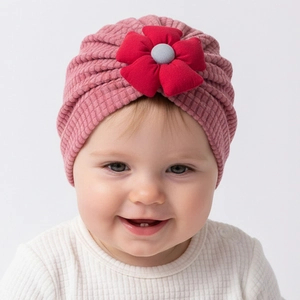 Detail of pink waffle knit baby turban hat featuring a 3D red flower and soft texture
