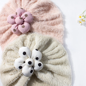 Dettaglio cappelli a turbante in peluche per neonati con fiori 3D a pois rosa e beige