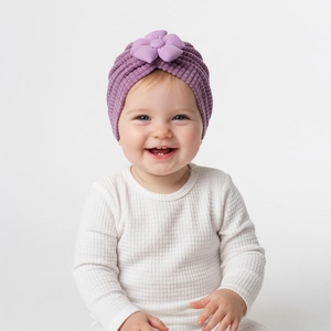 Detailed view of purple baby turban hat with a 3D floral accent and soft ribbed texture