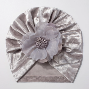 Détail d'un bonnet turban en velours gris argenté avec une grande fleur en mousseline