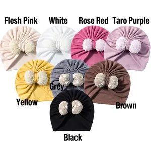 Detailed view of infant turban hats in eight colors with large lace bow decorations