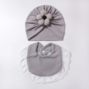 Dettaglio set cappello e bavaglino neonato in maglia a nido d'ape con pizzo e fiori