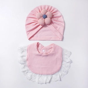 Dettaglio di cappellino neonato rosa in maglia e bavaglino con pizzo e fiori