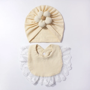 Dettaglio set cappello a turbante e bavaglino per neonati con fiore e pizzo elegante