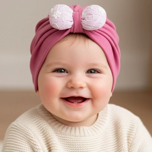 Detailed view of baby girl turban hat in pink cotton with large bow and soft knit texture