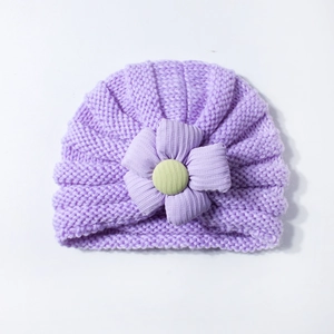 Close-up of purple knit baby turban hat featuring a large 3D fabric flower detail