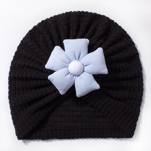 Detail of baby turban hat featuring a 3D blue fabric flower and waffle knit texture