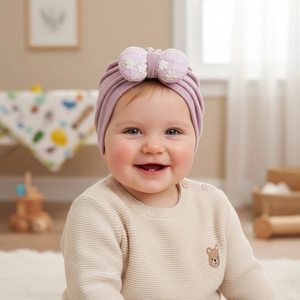 Detailed close-up of light purple baby turban hat with embroidered white flower bow