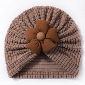 Detailed macro of coffee brown waffle knit baby beanie featuring a 3D floral decoration