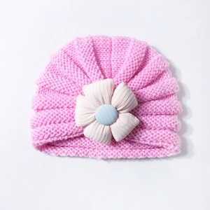 Pink knit baby turban hat with large decorative flower for autumn and winter warmth