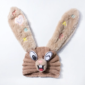 Close-up of knit baby hat with long plush bunny ears and colorful heart embroidery