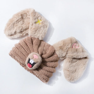 Brown knitted baby hat with plush rabbit ears and cute embroidered character facial details