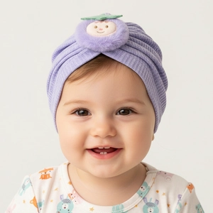 Close-up of baby waffle knit turban hat with a purple plush ball and smiling face design