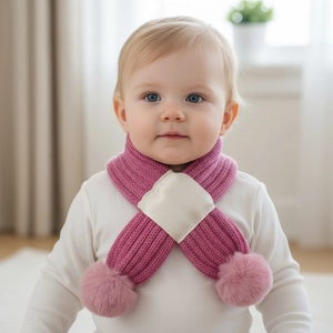 Pink knit scarf for babies with fuzzy pom-poms and crisscross design for autumn warmth