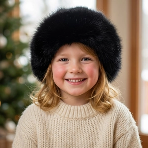 Close-up of a child wearing a black fluffy faux fur Mongolian hat for winter warmth