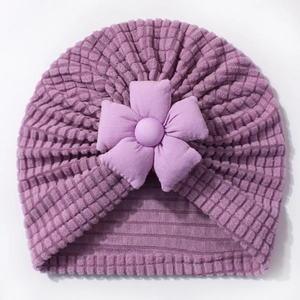 Close-up of purple waffle knit baby turban hat with a 3D decorative fabric flower