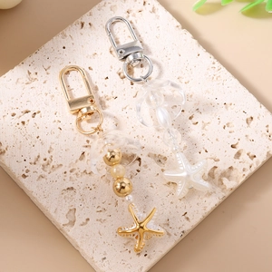 Porte-clés perlé étoile de mer avec fleurs acryliques et finitions or ou argent