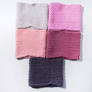 Detailed close-up showing thick knit textures in beige, pink, purple, and grey yarn colors